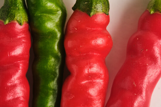 Extreme macro close up showing the vivid skin texture red and green spicy hot chili peppers.
