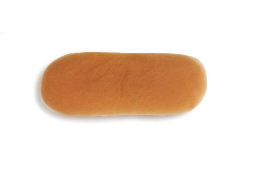 Top view golden baked elongated hot dog bun isolated on solid white backdrop.