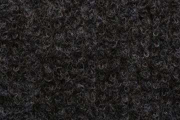 Macro close up texture dark curly synthetic wool or loop pile carpet fibers background pattern. © freeman83
