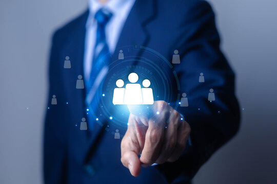 Businessman using a digital team network icon, symbolizing teamwork, recruitment, human resources, leadership, collaboration, employee management, networking workforce planning, organizational growth.