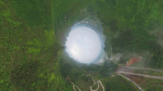 Drone view tunnel effect landscape of green mountains, agriculture field, zigzag road in Fengtang village, Hechi, Guangxi, China, 4k real time footage travel concept b roll shot.