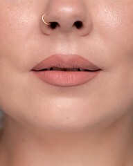 Obraz premium Natural nude matte lipstick on lips close up