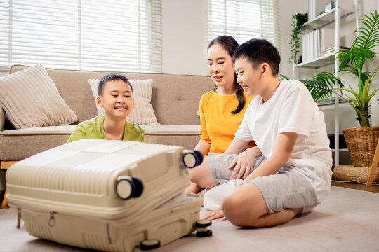 Family Packing Clothes Together in a Suitcase for Vacation