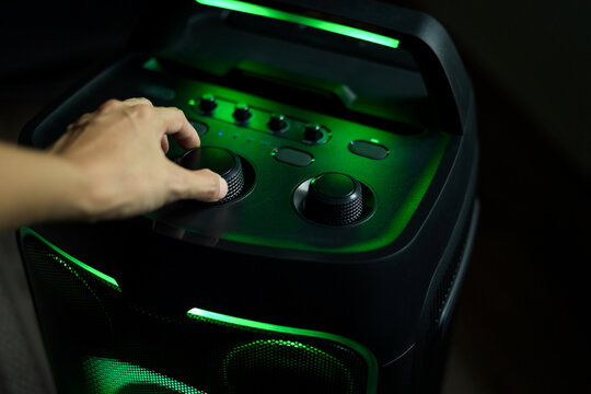 Close up hand using the function buttons of a sound audio speaker to listen to music, Concept of people and the use of technological devices is spreading widely.