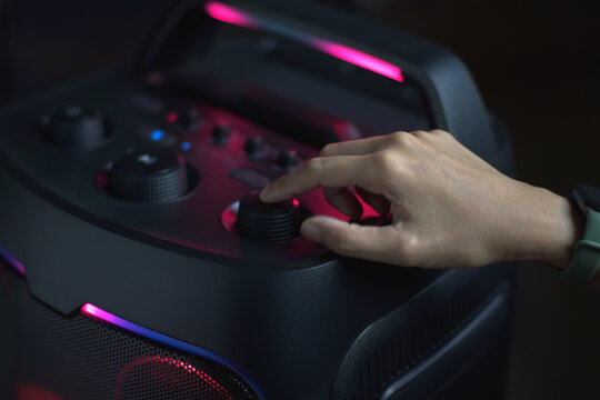Close up hand using the function buttons of a sound audio speaker to listen to music, Concept of people and the use of technological devices is spreading widely.