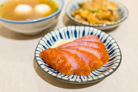 Sliced red sausage served on patterned ceramic plate