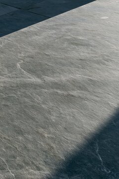 Closeup of raw slate limestone texture in a Tropical Modernism outdoor kitchen, natural veining highlighted by warm afternoon light
