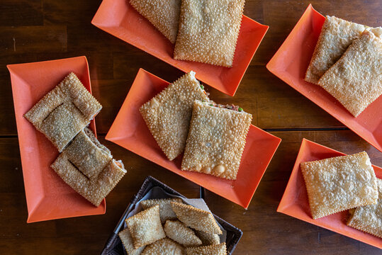Brazilian pastel pastries served on orange plates