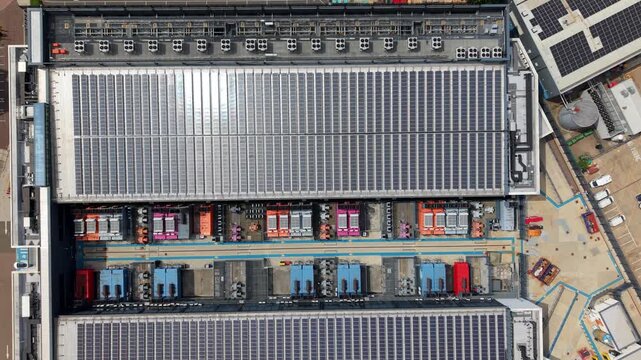 Aerial view of the NTT 3 Data Center featuring extensive rooftop solar panels and industrial cooling units in Hemel Hempstead, England, United Kingdom.