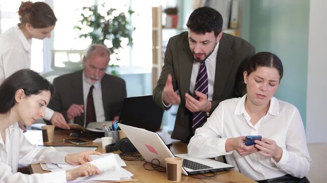 Man boss found girl subordinate idling and scrolling phone, mentor shouts at subordinate. Scrolling of phone and social networks 