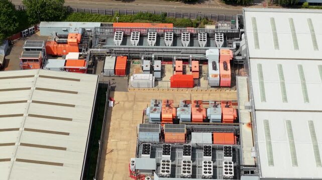 Aerial view of the NTT global data center featuring industrial cooling units and power infrastructure on the rooftop in Hemel Hempstead, England, United Kingdom.