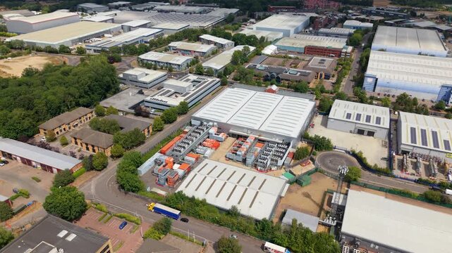 Aerial view of the NTT global data center facility surrounded by industrial warehouses, roads, and green spaces in Hemel Hempstead, England, United Kingdom.
