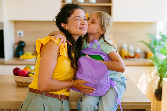 Mother and daughter sharing an affectionate goodbye before school