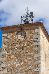 An ancient stone clock tower featuring Roman numerals and a bell turret © wundermann