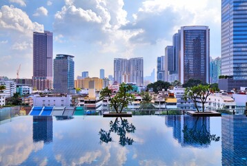 Obraz premium Kuala Lumpur modern city skyline of Brickfields district with reflection in infinity pool. Kuala Lumpur, Malaysia.