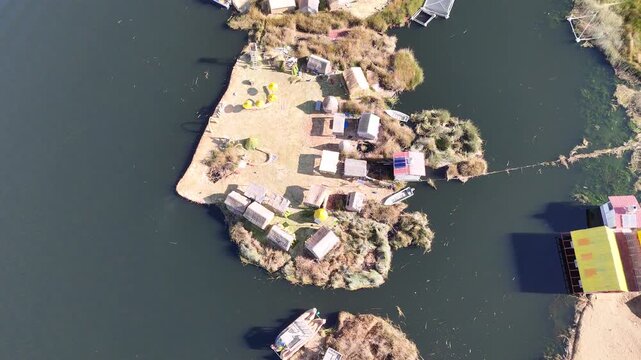 Overhead drone footage capturing the intricate layout of the Uros floating islands made of totora reeds in Peru.