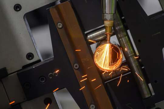 Front view of fiber laser cutting machine engraving stainless steel tube with sparkling light sparks