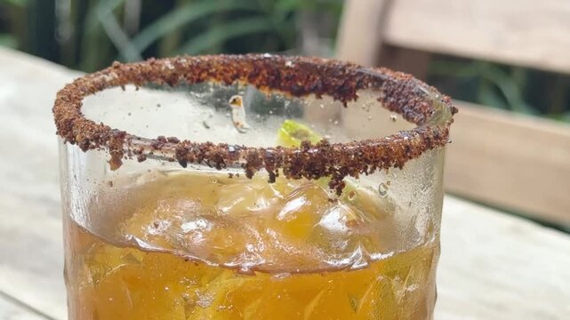 Chilled Tepache Fermented Pineapple Drink with Tajin Chili Rim in Glass 