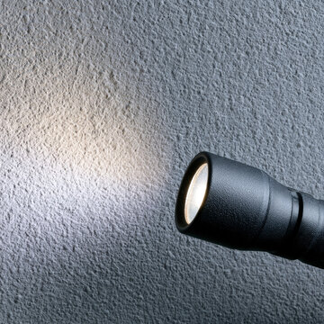 Black Flashlight Beam on Textured Wall for Emergency Lighting Portable Safety Equipment Security Inspection and Outdoor