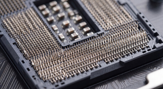 Extreme close up view of an empty LGA processor socket on a computer motherboard with hundreds of delicate gold contact pins