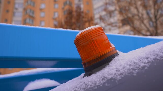 Flashing Orange Beacon Warning Light Covered in Snow Close Up