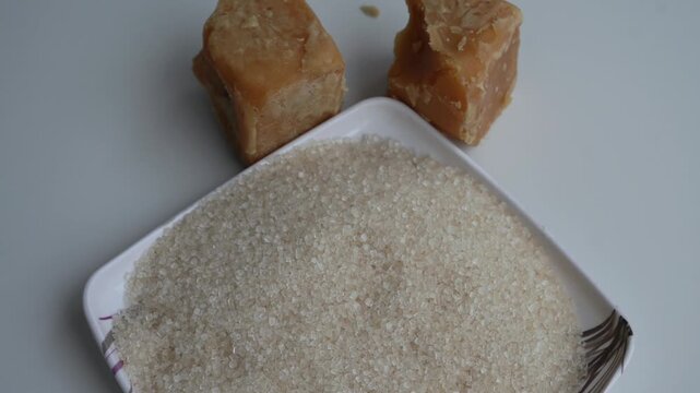 Jaggery cubes and a bowl of granulated sugar