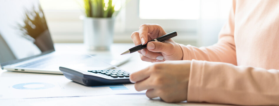 Deduction planning concept. Asian young woman hand using calculator to calculating balance prepare tax reduction income, cost budget expenses for pay money form personal Individual Income Tax Return