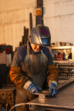 Industrial welder securing metal pieces with clamp before welding