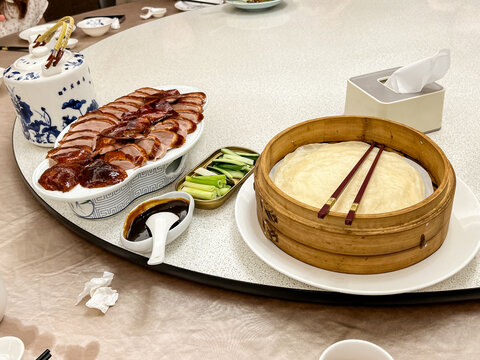 A refined Cantonese dining collection showcases a selection of Hong Kong-style dishes, including crispy roast duck, fresh shrimp, garlic-fried squid, slow-cooked duck soup, braised vegetables, and mol