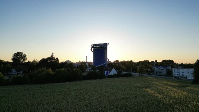 Aerial Ascent from Fields as the Sun Emerges behind the Energy Storage Tower in Heidelberg Pfaffengrund, Germany