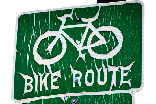 Old Worn and Weathered Bike Route Sign on Road Green and Flaking Paint