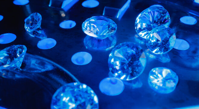 Loose polished diamonds on illuminated blue tray for gem grading, jewelry display and marketing background for laboratory mining factory