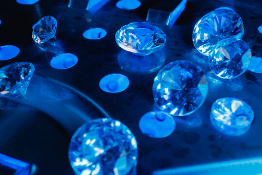 Loose cut diamonds on metallic tray under blue illumination for luxury jewelry product for laboratory mining factory