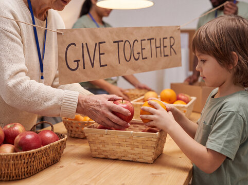Older adult helping a child with fruit