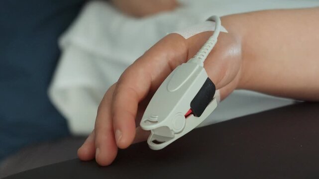 Title:
Pulse Oximeter Finger Sensor Monitoring Patient Oxygen Saturation in Hospital Bed
