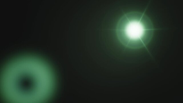 Bright green lens flare with glowing light effect on dark background.
