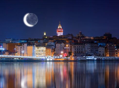 Galata Tower, Galata Bridge, Karakoy district and Golden Horn with motion speed light of passing ferry in the foreground at night istanbul - Turkey  