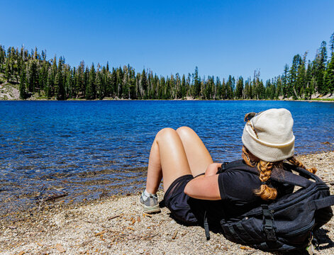Young Female Hiker Enjoying The Beautiful Turquoise Waters of Shadow Lake on The Terrace, Shadow and Cliff Lakes Trail, Lassen Volcanic National Park, California, USA