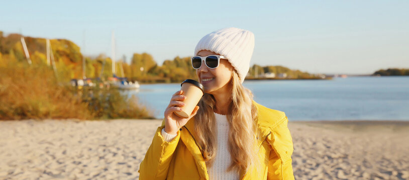 Stylish happy woman standing on beach, girl smiles, looking away on sea