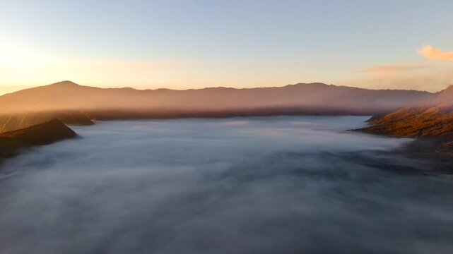 Aerial view of Mount Bromo volcanic landscape at sunrise with a sea of clouds covering the caldera in Tosari, East Java, Indonesia.