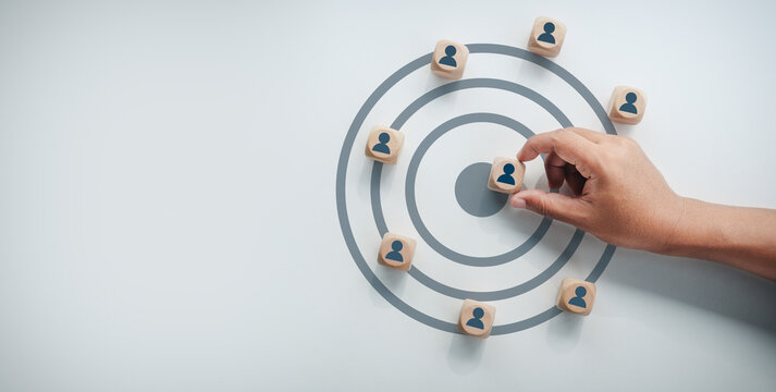 Business professional placing wooden block with human icon into target bullseye center, targeting customer concept, business strategy, human resources recruitment, goal achievement, target audience.
