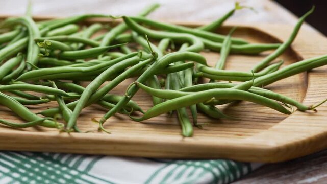Flat lay view of raw French beans piled on a wooden background