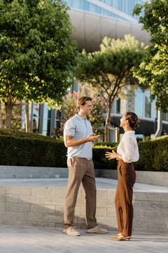 Couple enjoying a lively conversation in a modern outdoor park setting
