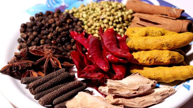 Set of dried Indian spices in serving plate table top view spin.