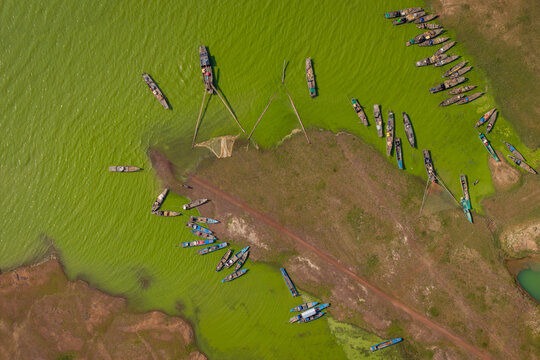 Aerial view of traditional fishing boats gathered on green waters at Ben Nom, Vietnam.