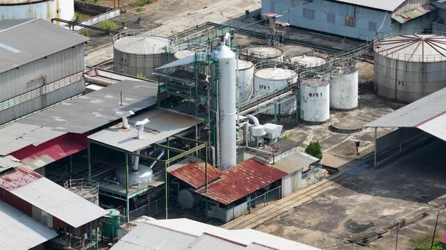 Industrial palm oil refinery complex with large storage tanks and processing infrastructure