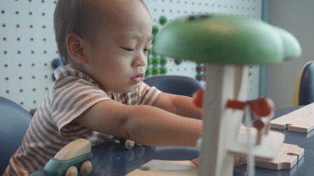A young child focused on a colorful interactive toy, enjoying playtime in a stimulating environment. The scene captures the essence of early childhood development through play and exploration.