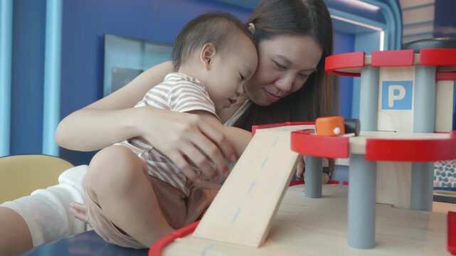 A heartwarming scene of a mother and her young child playing together at a toy garage, fostering bonding and creativity through playtime. It's a perfect example of nurturing relationships and childhoo