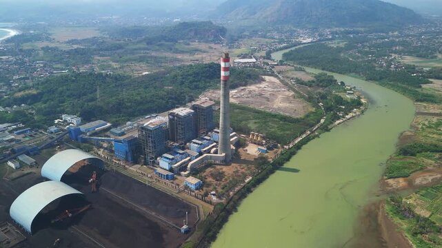 Aerial view of large electricity generation facility with factory buildings and cooling systems symbolizing industrial advancement and reliable energy supply.