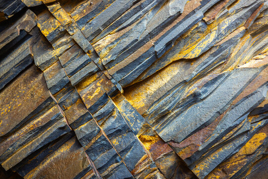 View of layered sedimentary rock formations at Tuzbair, showing distinct geological strata with yellow and grey mineral deposits in Mangystau District, Mangystau Region, Kazakhstan.